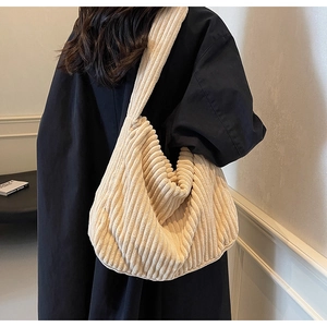Detail of beige corduroy tote bag showing soft ribbed texture and casual slouchy style