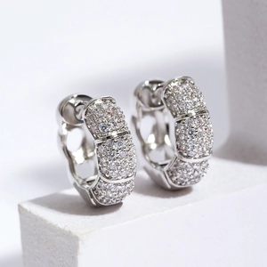 Silver pave-set zircon bamboo hoop earrings on minimalist stone display for unisex