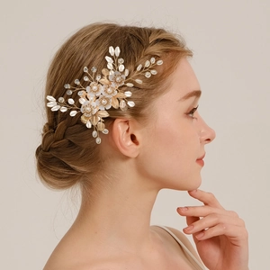 Golden flower bridal hair clip with pearls and crystals worn on braided hair