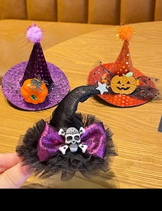 Close-up of Halloween mini hats featuring spider, pumpkin, and skull motifs on a wooden table