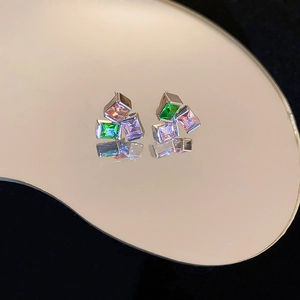 Detailed view of geometric earrings with green pink and purple square zircon stones