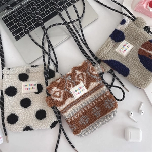 Détail de sacs bandoulière en peluche à pois et motifs ethniques dans un cadre lifestyle