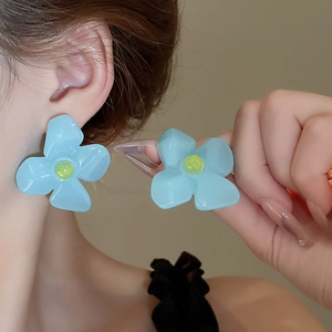 Gros plan de boucles d'oreilles fleurs bleues mates avec perles jaunes de style d'été