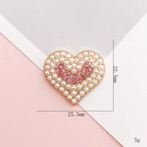 Detail of heart shape alloy accessory with white pearls and pink rhinestones