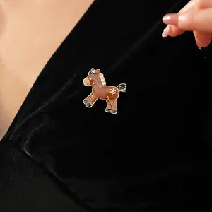 Elegant pony brooch with enamel finish and sparkling crystals on premium black velvet