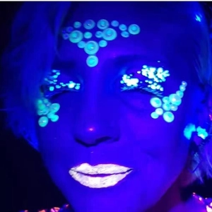 Luminous face jewels with flower and round patterns glowing under UV light for festivals