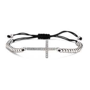 Macro shot of silver-beaded cross bracelet with white zircons and adjustable black rope