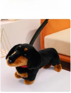 Detail of dachshund plush toy with red collar and green leash on a white surface
