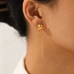 Elegant gold stainless steel beaded tassel earrings with U-shaped drop design on model