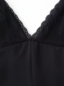 Close-up of black V-neck bodice featuring delicate lace patchwork and smooth fabric