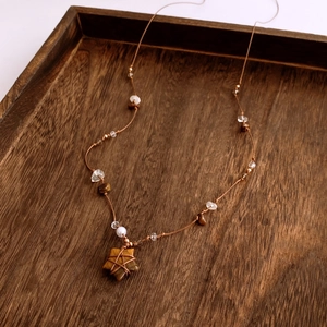 Detail of bohemian woven necklace featuring a star tiger eye pendant and mixed beads