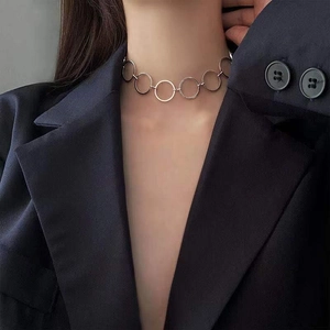 Fashionable silver metallic choker necklace featuring linked circular rings on a model