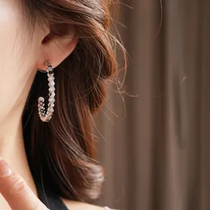 Silver geometric C-shaped hoop earrings with hexagonal honeycomb texture and crystals