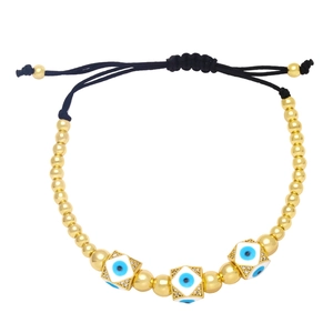 Detailed view of adjustable evil eye bracelet with gold beads and white enamel charms