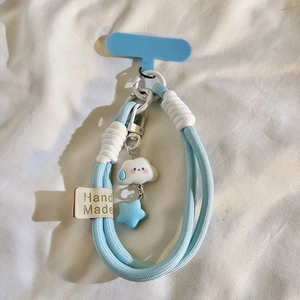 Detailaufnahme eines blauen Handybandes mit weißem Wolkenanhänger und blauem Stern