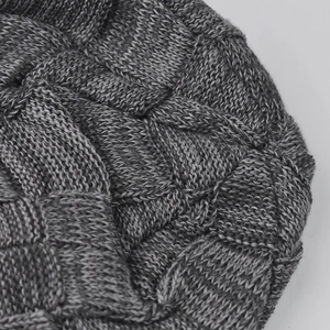 Detailed close-up of dark grey thick knit pattern showing textured plaid weave fabric