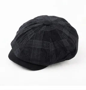 Détail d'une casquette gavroche en velours côtelé noir avec motif à carreaux