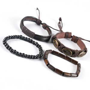 Detail of four-piece bohemian brown leather and black bead bracelets set with shell charm