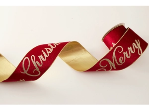 Macro detail of red velvet Christmas ribbon with gold Merry Christmas lettering