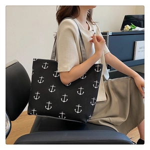 Large capacity black canvas tote bag with nautical anchor print shown in a lifestyle setting