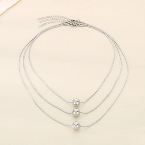 Detailed view of three minimalist silver snake bone necklaces with polished beads