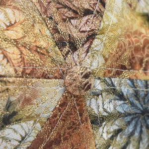 Detailed macro view of sparkling gold glitter fabric and ornate embroidery on cap crown