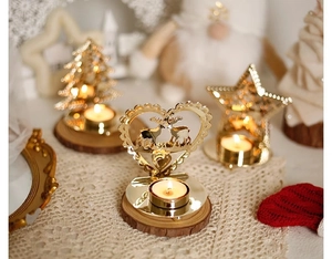 Close-up of golden metal Christmas candle holder with star and deer cutout on wooden base