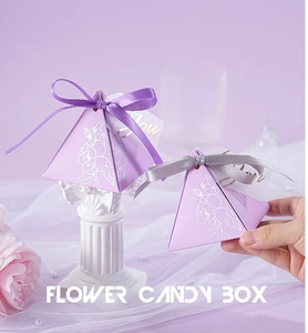 Detail of purple pyramid wedding candy box with silver floral prints and elegant ribbon bow