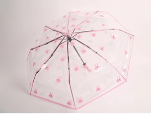 Detail van transparante lange paraplu met schattige roze konijnpatronen en afwerking