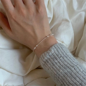 Minimalist 925 sterling silver snake chain bracelet with silver beads on a model wrist