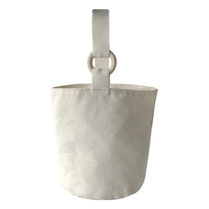 Minimalist cream canvas bucket tote bag featuring natural wooden ring handles for women