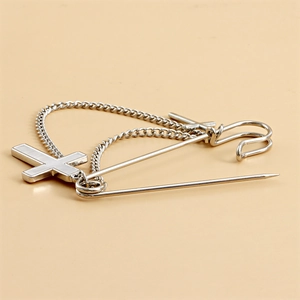Detail of silver cross brooch with chain tassels and white mother of pearl inlay