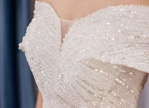 Macro detail of luxury wedding dress featuring silver sequins and beadwork on the neckline