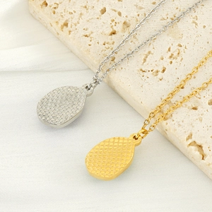 Detail view of gold and silver teardrop pendants with textured back on 18k plated chains