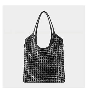 Close-up of black tote bag featuring intricate silver stud grid pattern and fine stitching