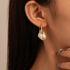 Vue détaillée de boucles d'oreilles en perles baroques avec crochets dorés élégants