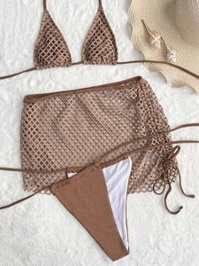 Close-up of brown crochet three-piece bikini set with mesh cover-up skirt on white fur