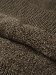 Gros plan sur un tricot côtelé marron foncé montrant la texture douce du tissu de haute qualité
