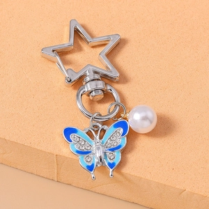 Macro shot of blue enamel butterfly keychain with crystal rhinestones and faux pearl bead