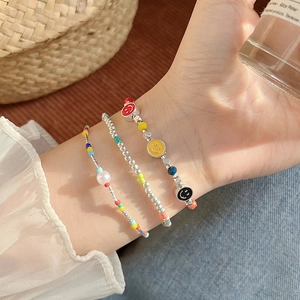 Close-up of summer star seed bead bracelets with smiley face and pearl charms