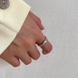 Detailed close-up of S925 sterling silver ring with irregular lava texture on model finger