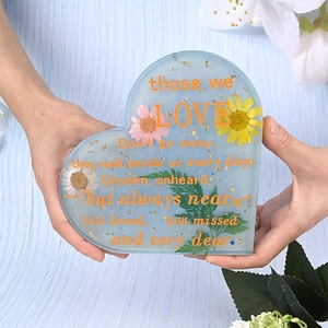 Heart-shaped resin memorial plaque with dried flowers, gold foil, and orange text