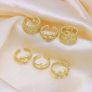 Set of six gold-plated open rings with heart zircon and beaded textures on champagne satin