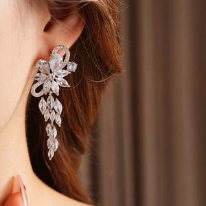 Close-up of sparkling zircon flower tassel earrings worn on model for luxury look