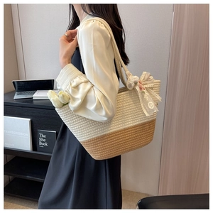 Detailed shot of woven tote bag in beige and brown with decorative white lace bow