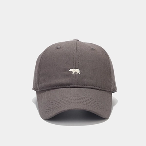 Close-up of white bear embroidery on charcoal grey cotton baseball cap with twill texture