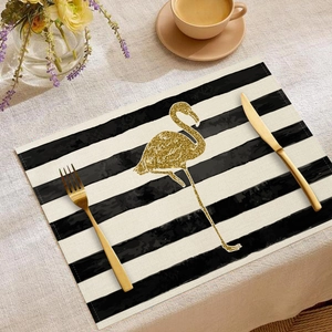 Elegant table setting with gold flamingo placemat, cutlery, and coffee on linen