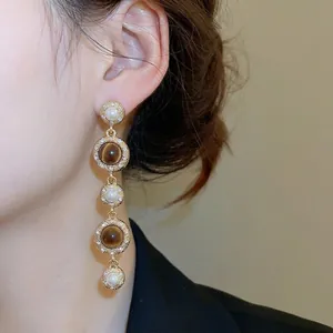 Elegant vintage drop earrings with pearls, tiger eye stones, and rhinestones in gold setting