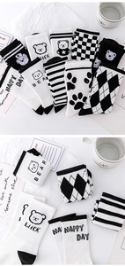 Detail of assorted cotton socks featuring stripes, checkered patterns, and bear embroidery