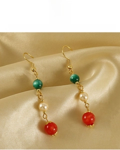 Détail de boucles d'oreilles plaquées or 18k avec perle, opale verte et agate rouge
